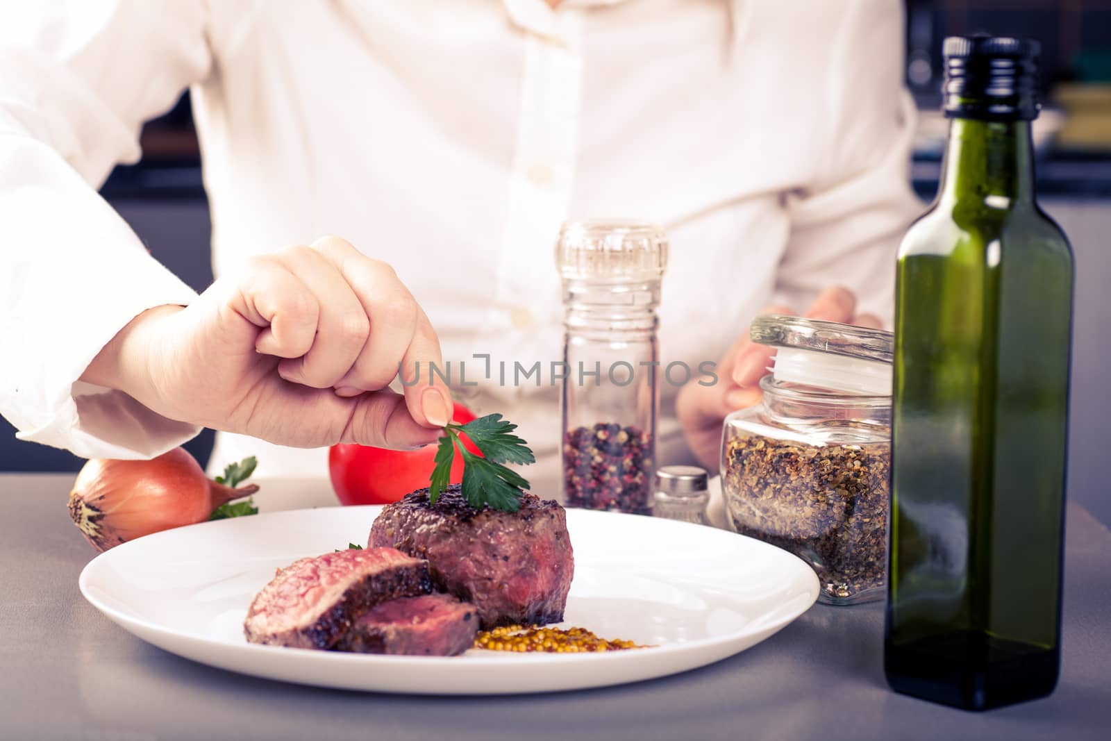 cook completes the dish of medallions, are nearby spices