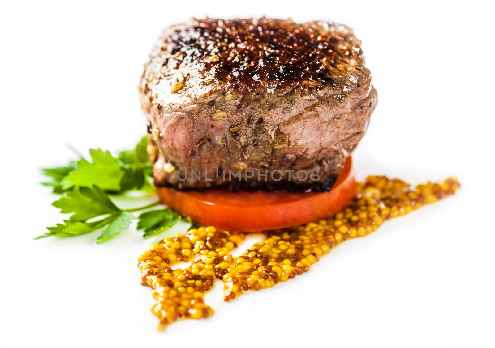 fried medallion with a slice of tomato sauce and greens on a light background