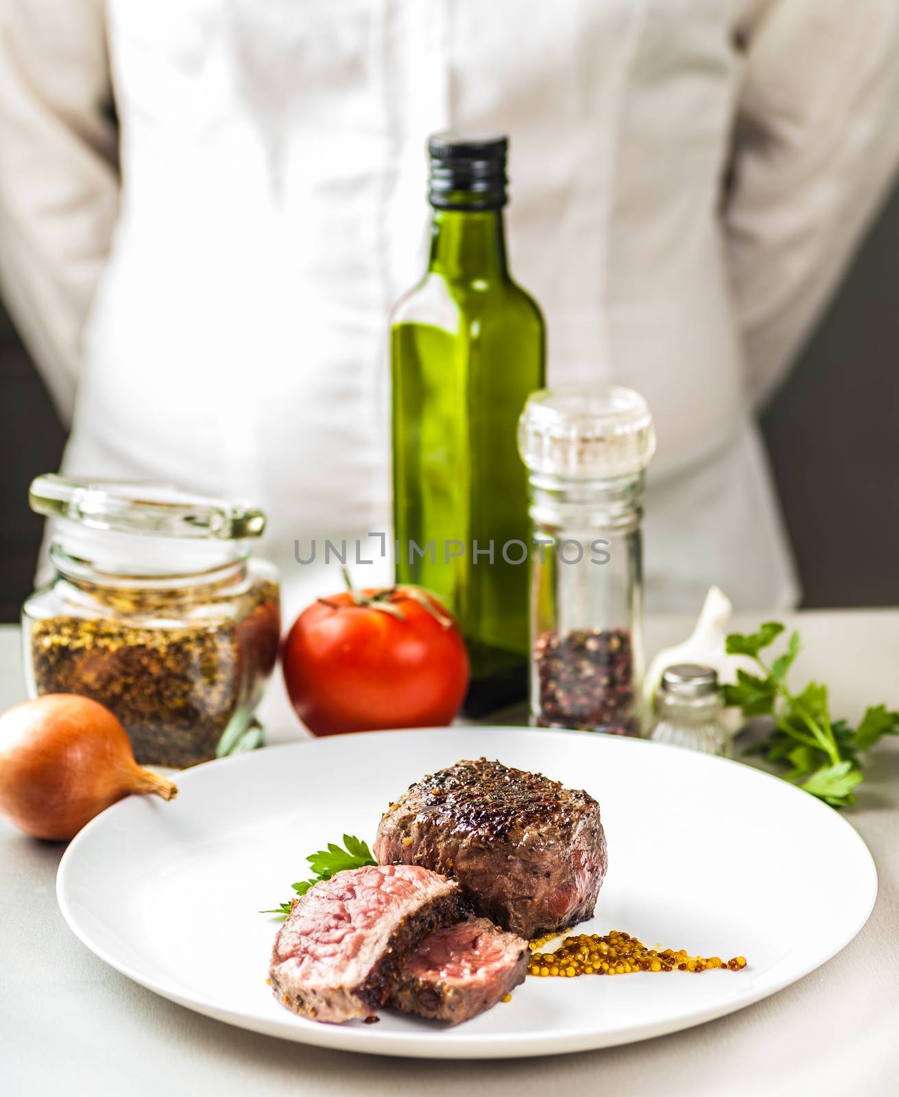 on the table spices, vegetables and a dish of fried medallion on a background of cooks