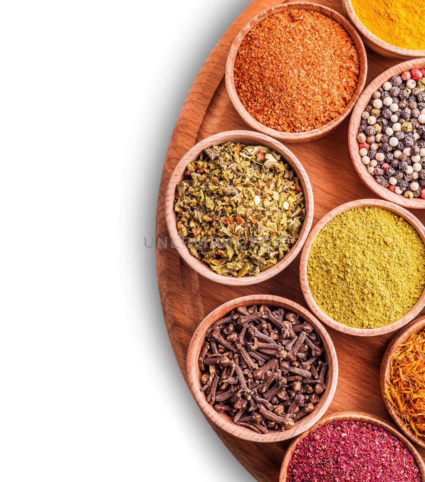 assorted spices in a wooden bowl on white background