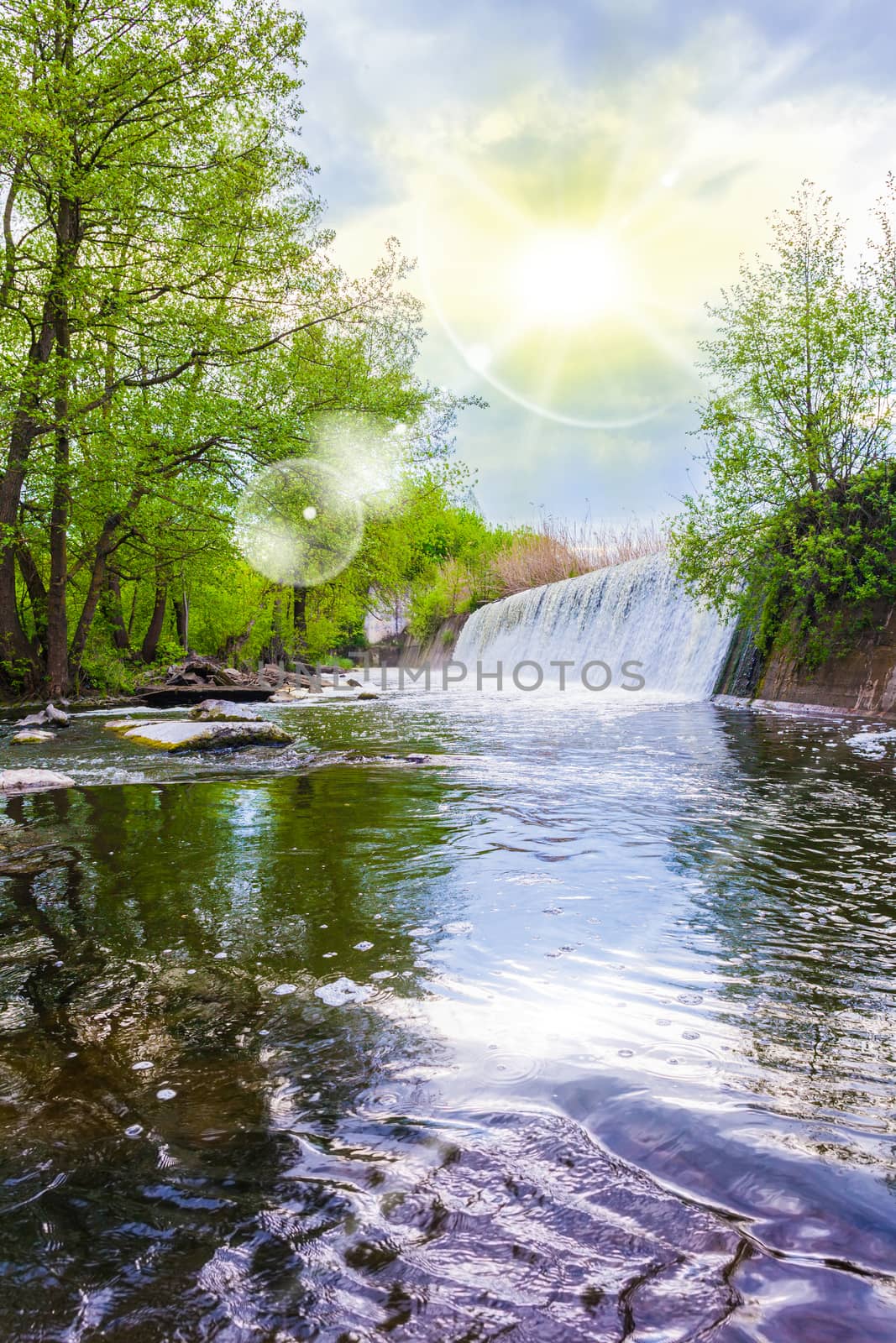 summer landscape waterfall flows into the river