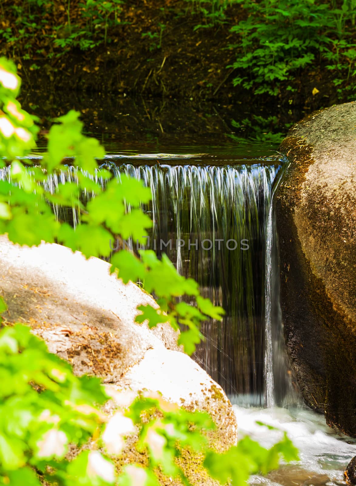 waterfall flowing over the stones closeup in forest