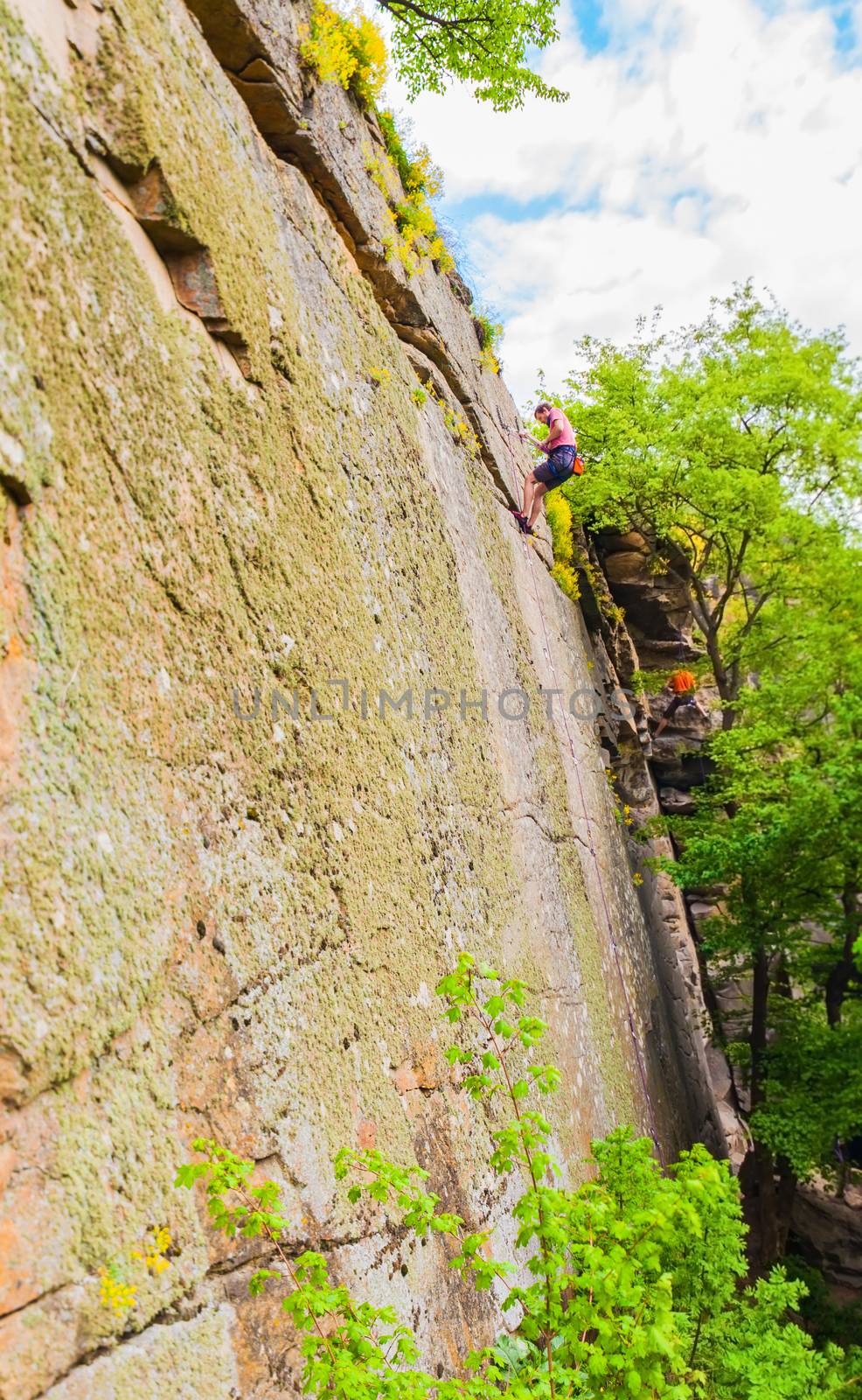 extreme sportsmen alpinists climbing up the cliff