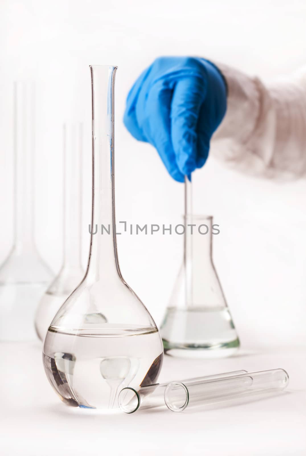 assistant mix reagents into the flask on a white background