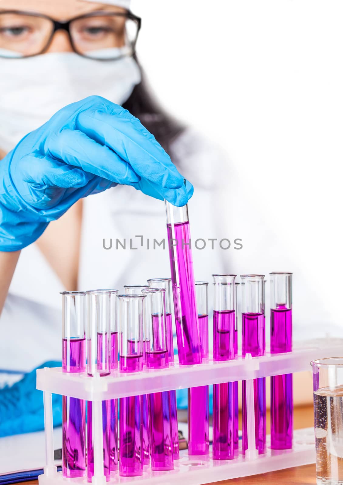 laboratorian inspects the contents of the test tubes on a light background