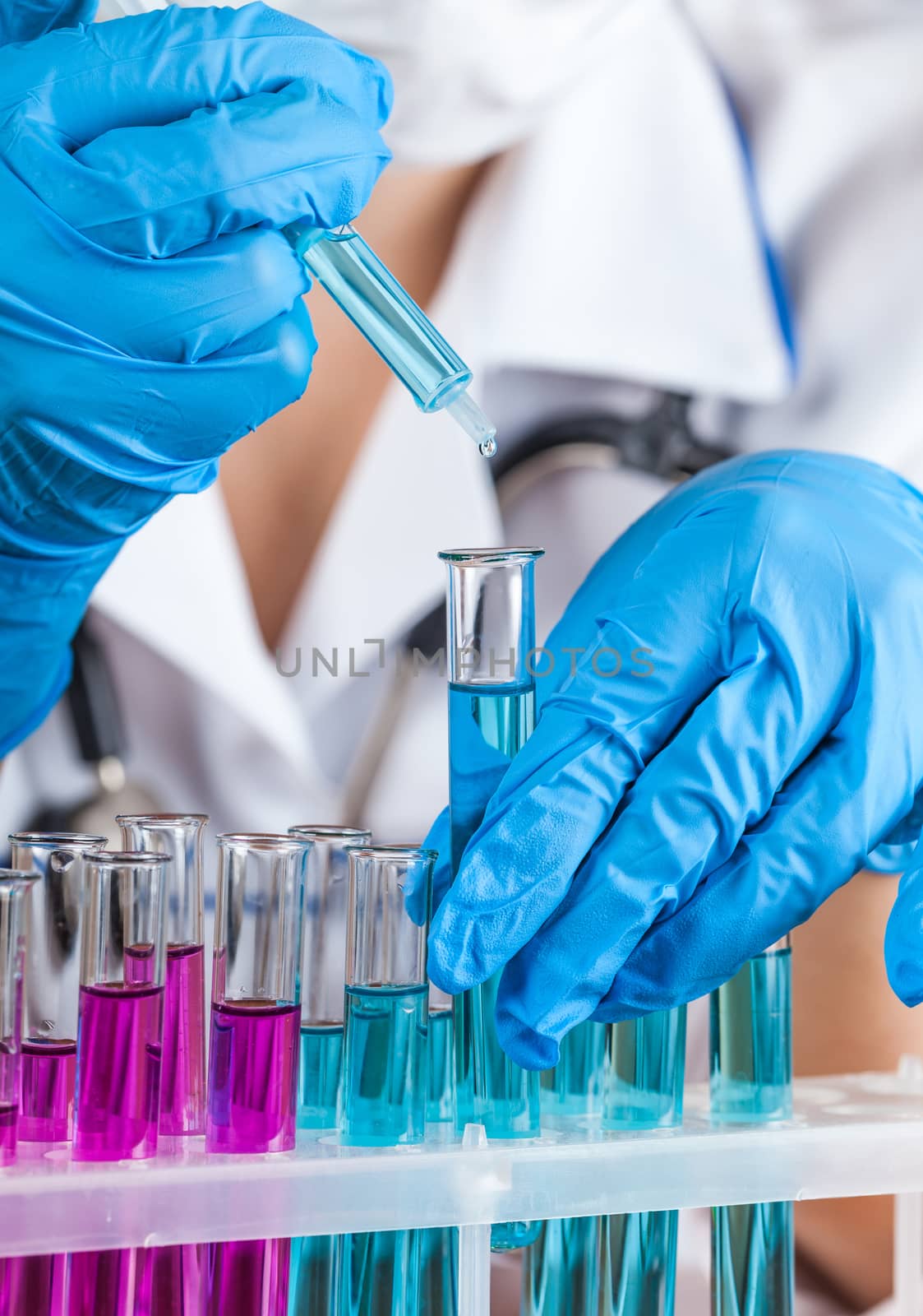 laboratorian reagent drips into the tube closeup