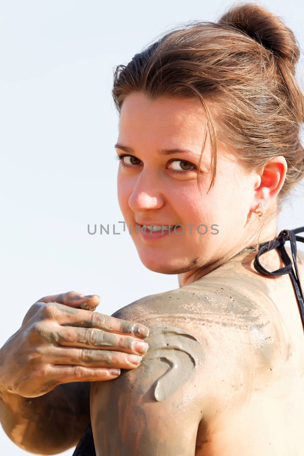 girl in a bikini rubs mud over health care