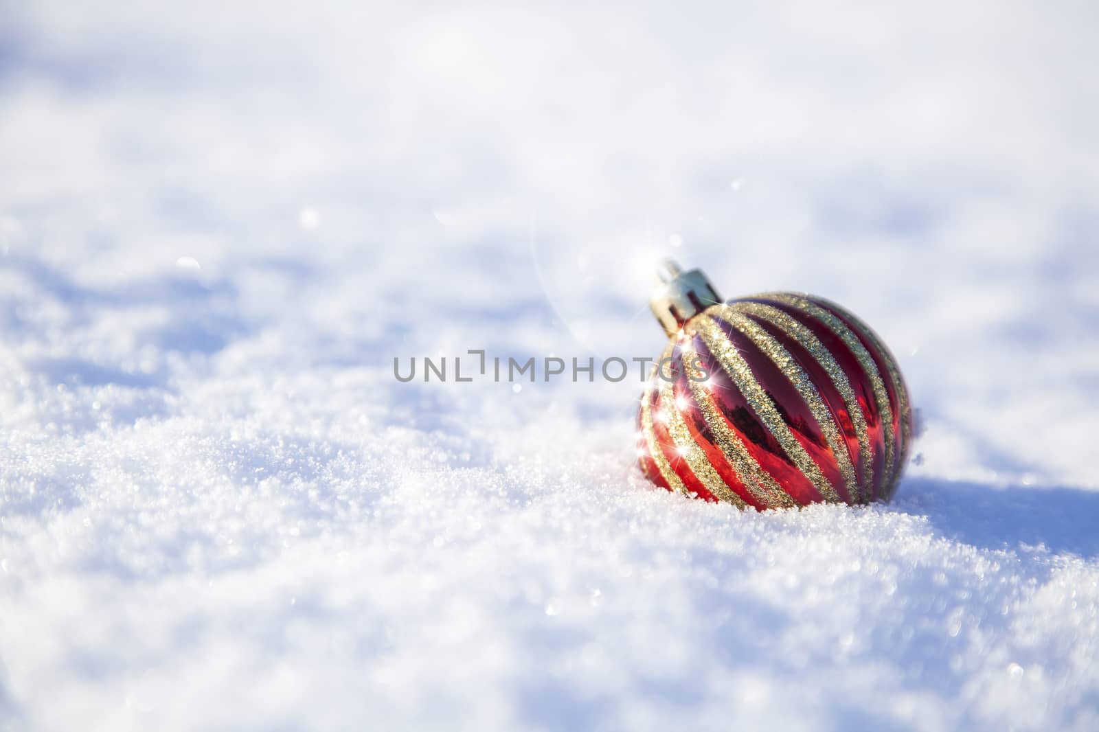 bright christmas decoration ball on a snowy background