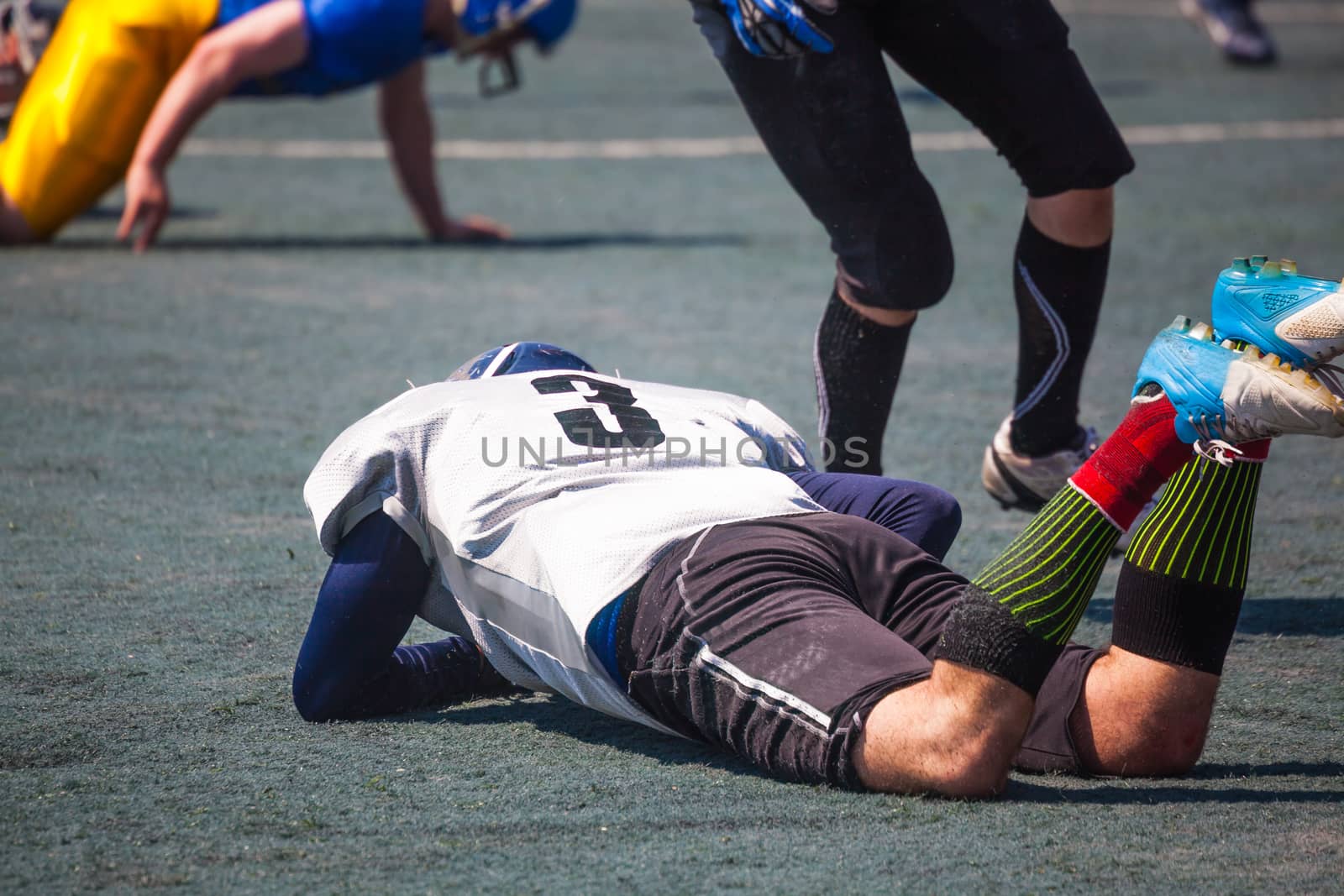 injured athlete lies on the grass of the stadium