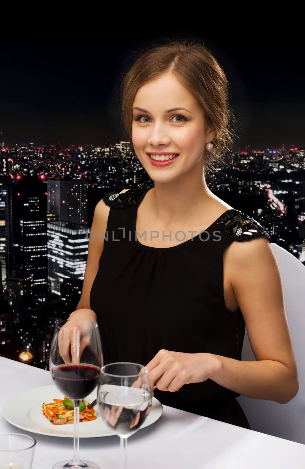 smiling young woman eating main course by dolgachov