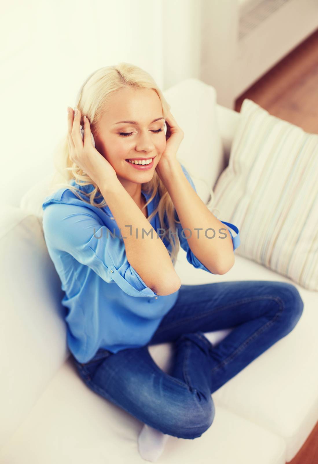 smiling young girl in headphones at home by dolgachov