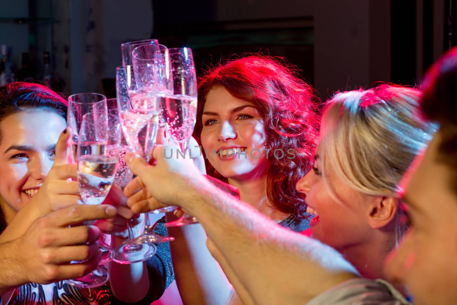 party, holidays, celebration, nightlife and people concept - smiling friends with glasses of champagne in club