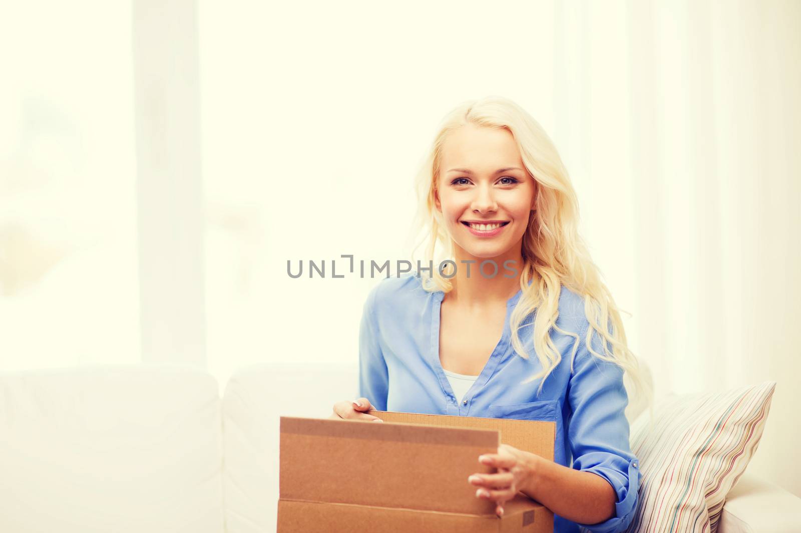 smiling young woman opening cardboard box by dolgachov