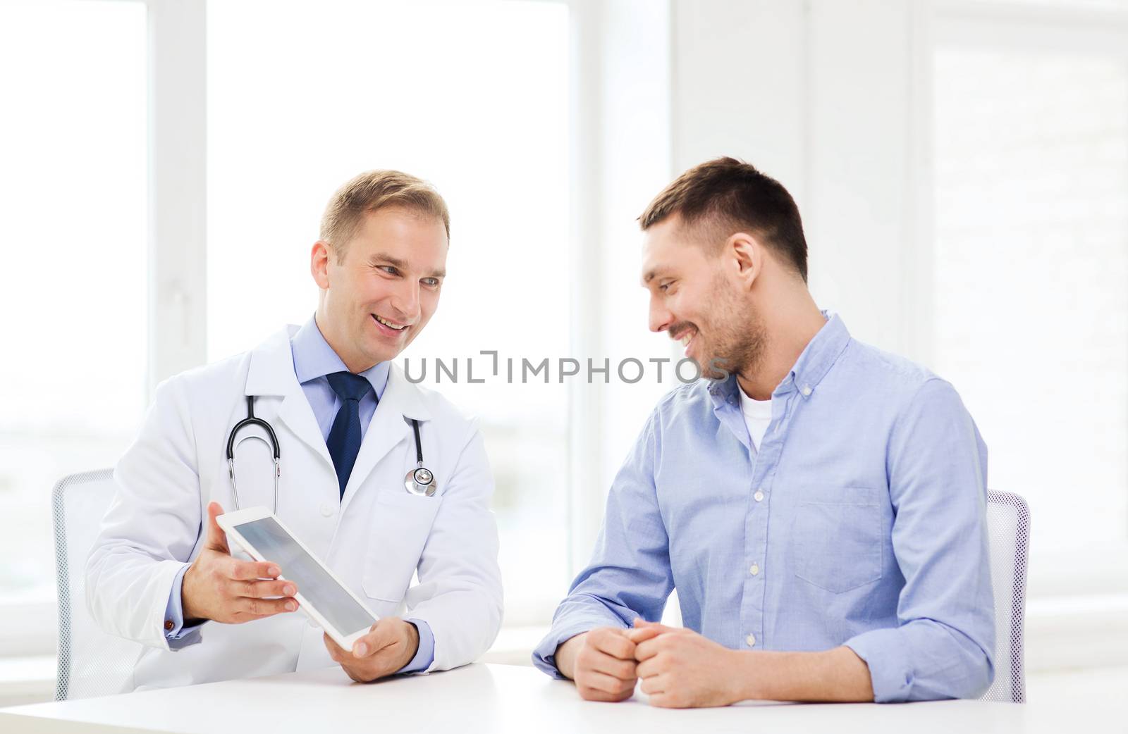 healthcare, technology and medicine concept - smiling doctor with tablet pc computer and patient in hospital