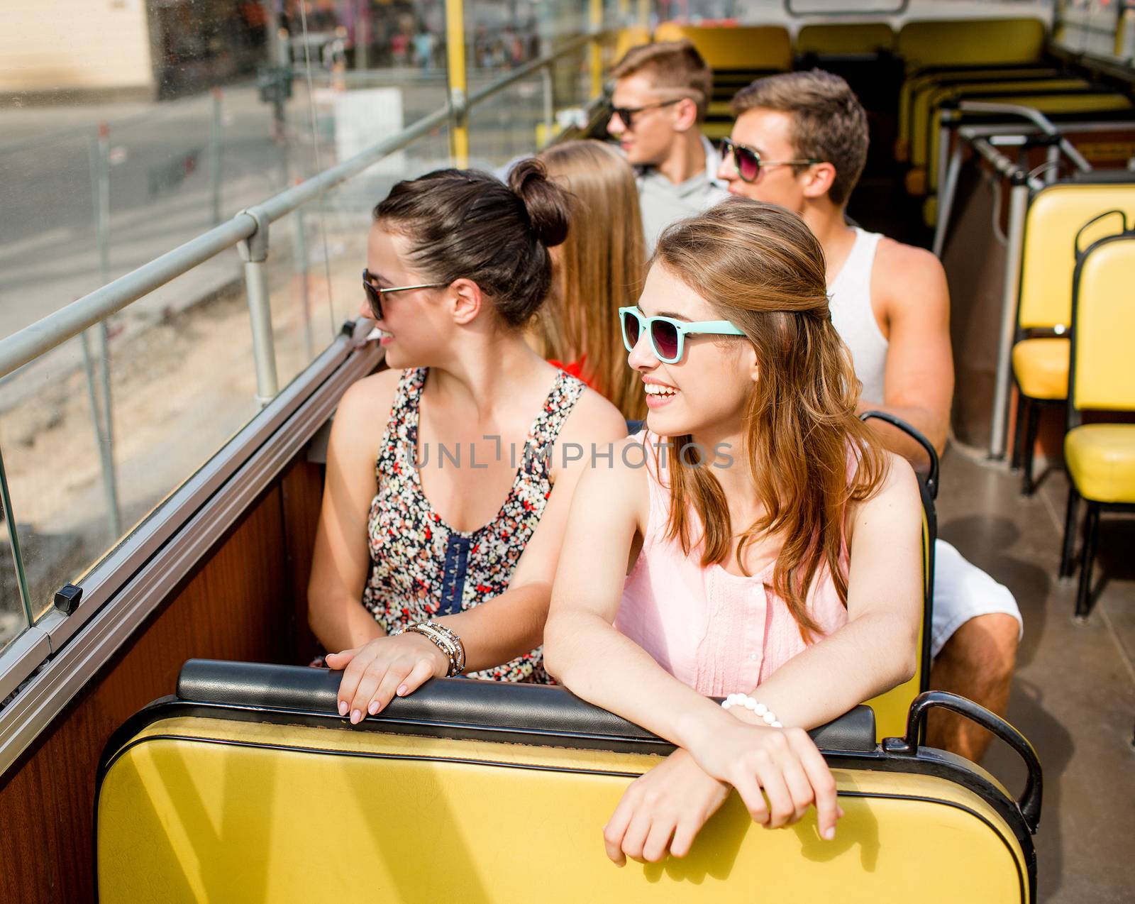 group of smiling friends traveling by tour bus by dolgachov