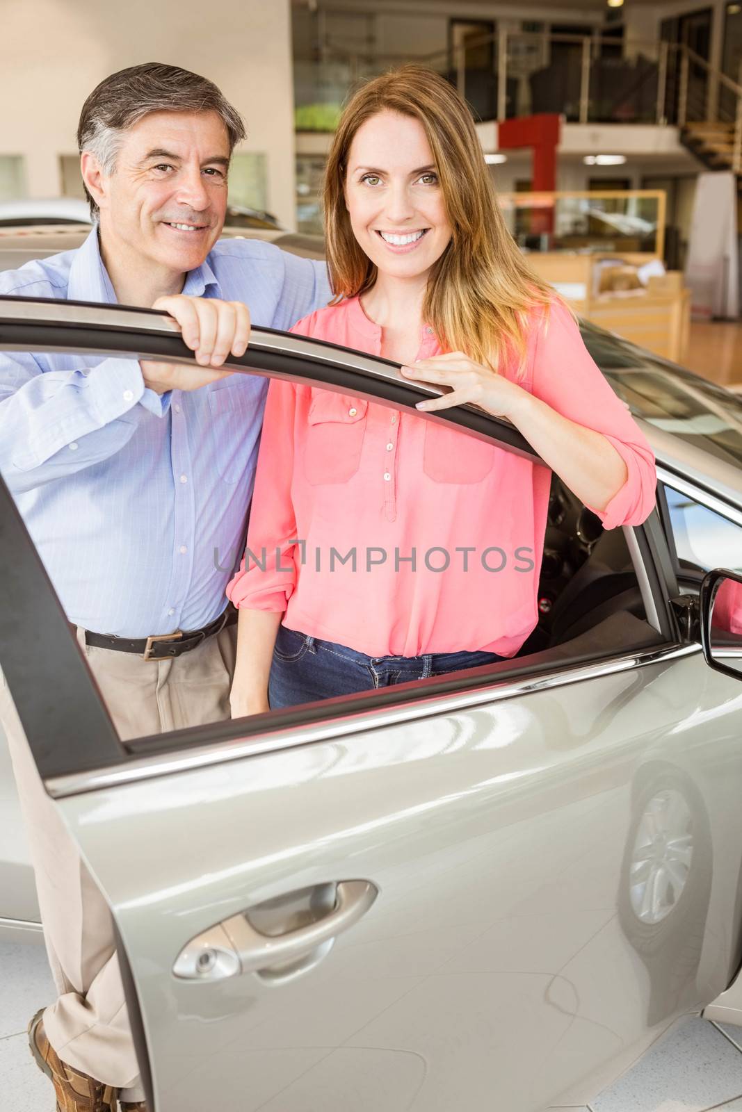 Smiling couple leaning on car by Wavebreakmedia