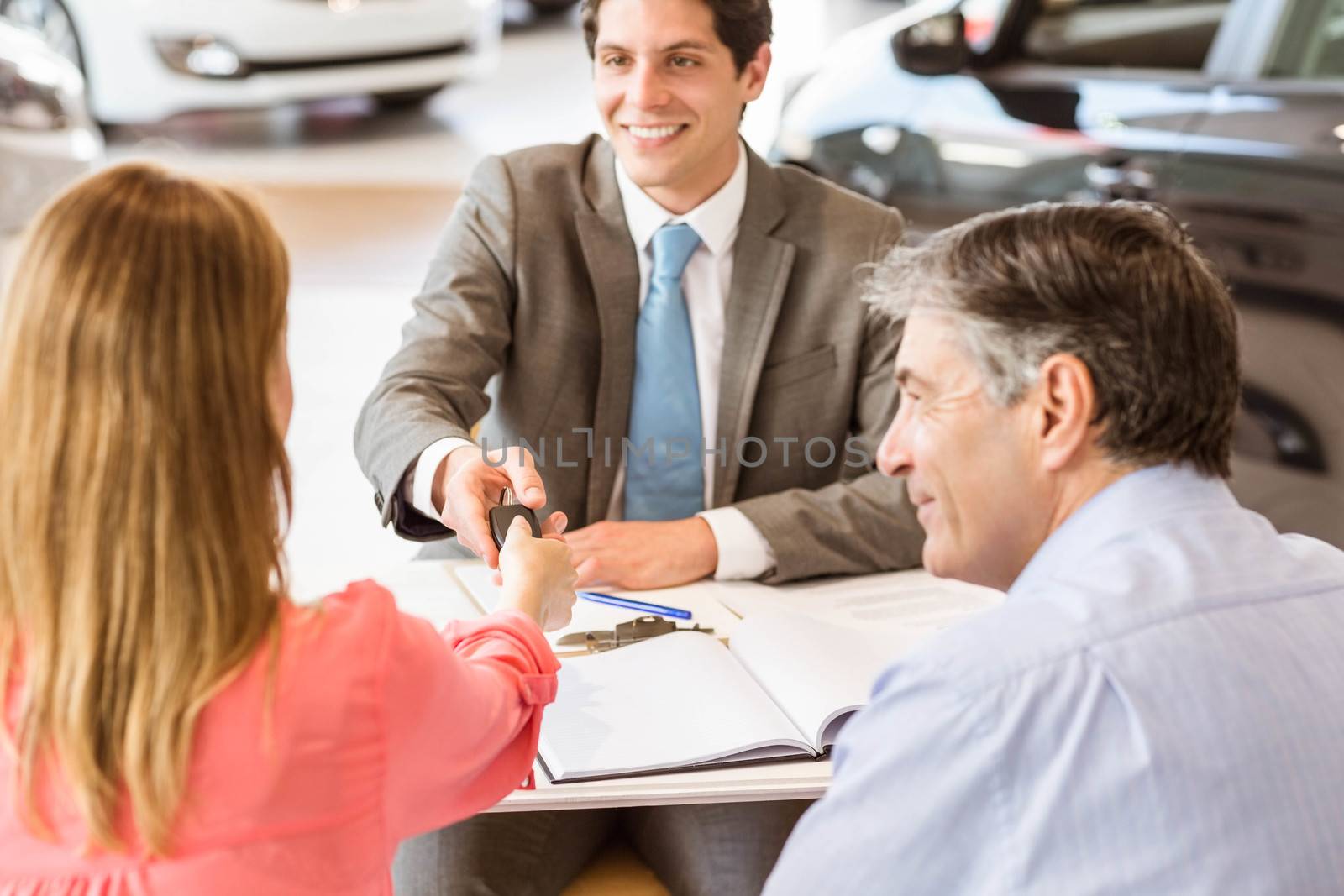Smiling couple buying a new car by Wavebreakmedia