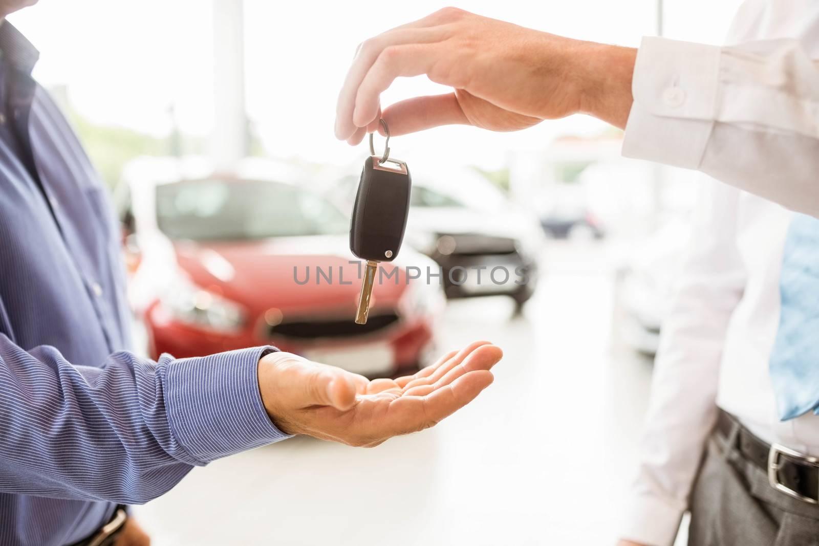 Businessman giving car key to a customer by Wavebreakmedia