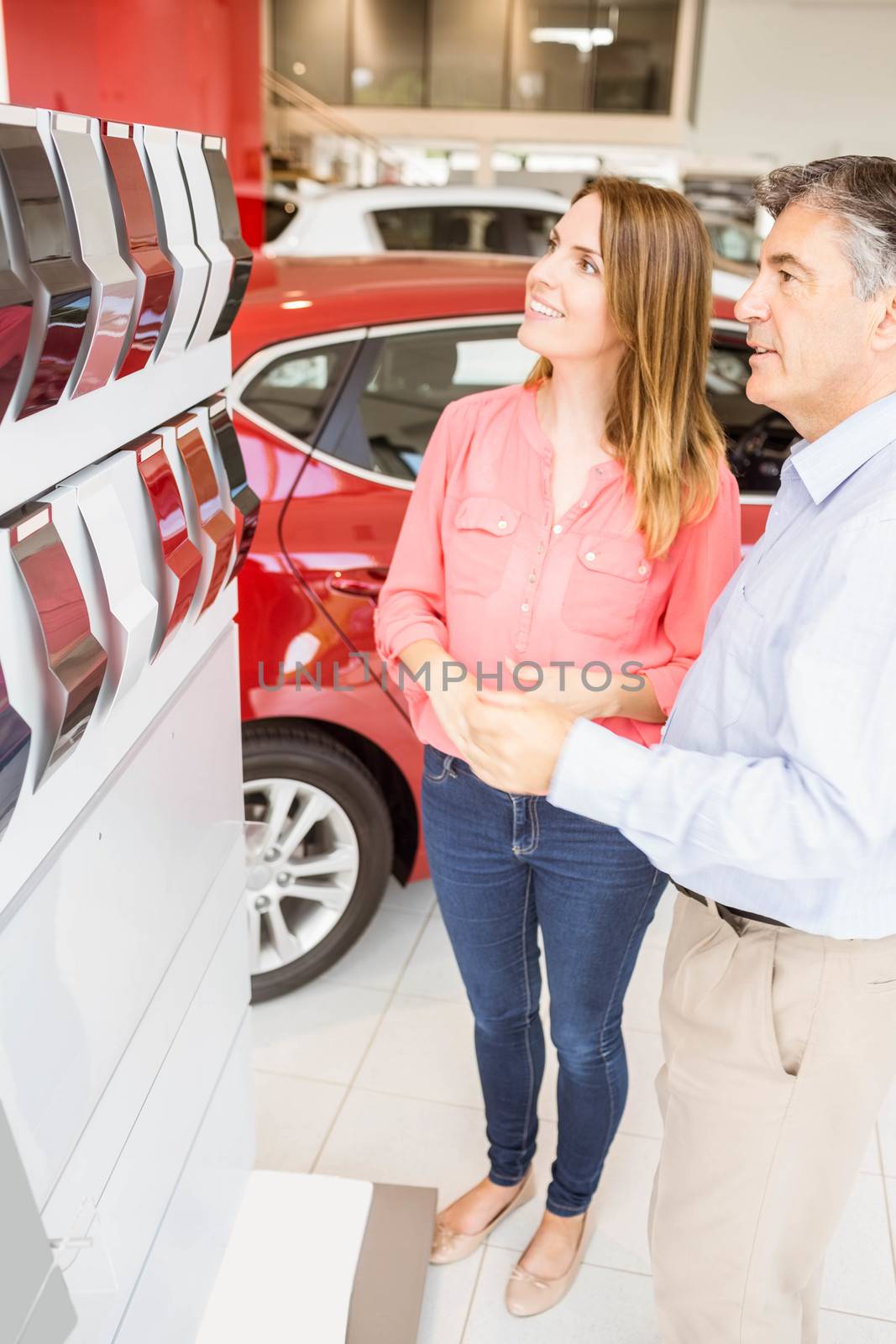 Smiling couple choosing the color of their new car by Wavebreakmedia