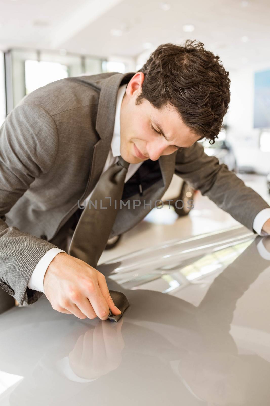 Focused businessman looking at the car body at new car showroom