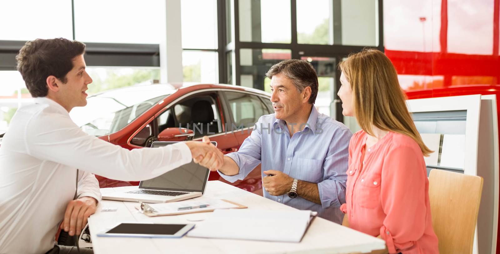 Customers signing some important documents at new car showroom