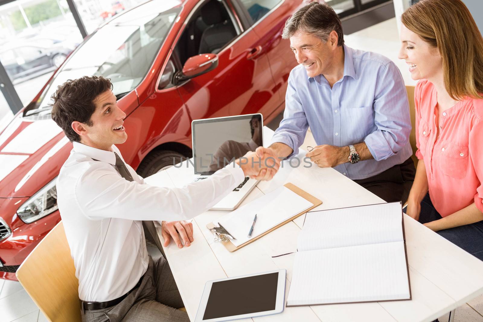 Customers signing some important documents at new car showroom