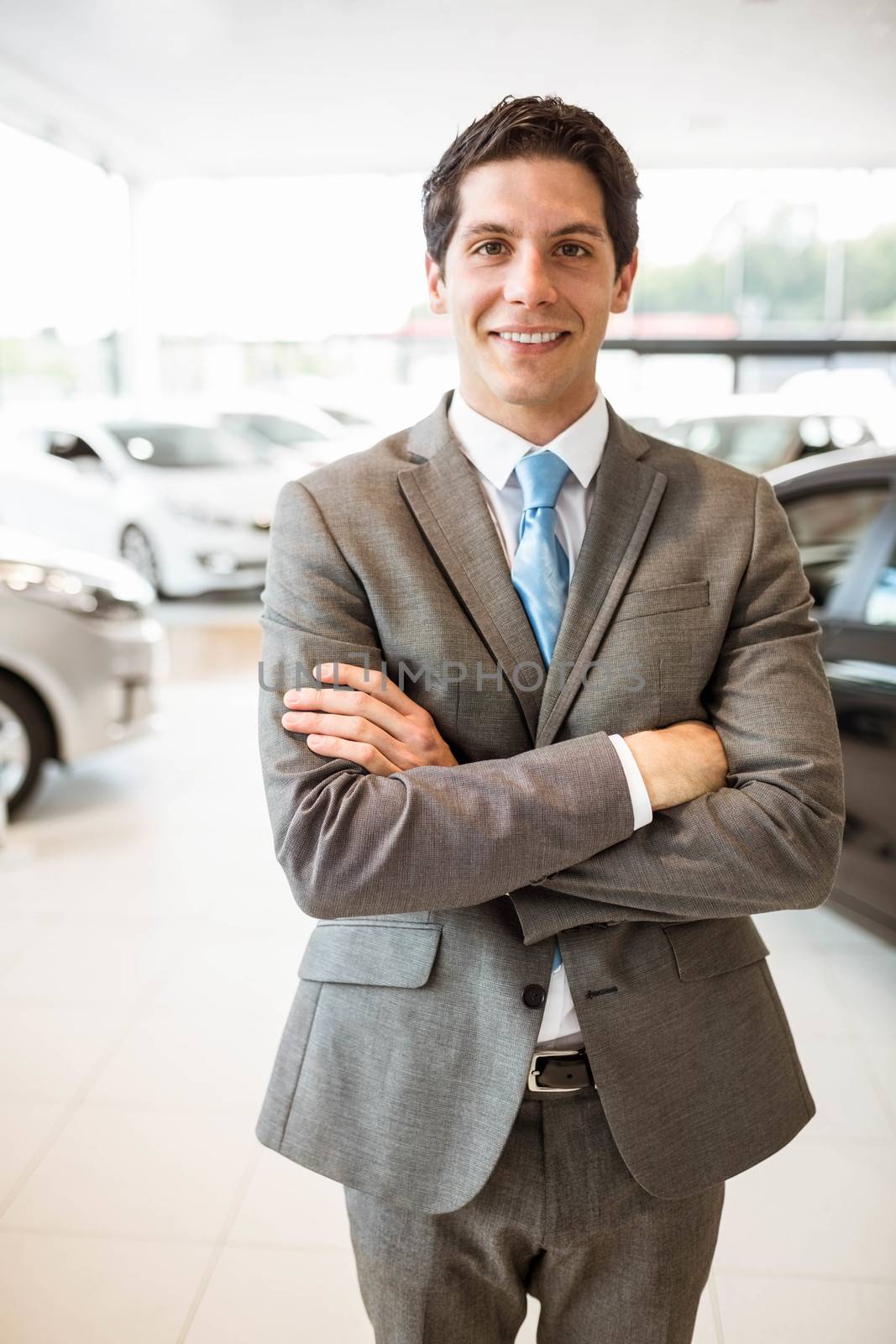 Smiling businessman standing with arms crossed  by Wavebreakmedia