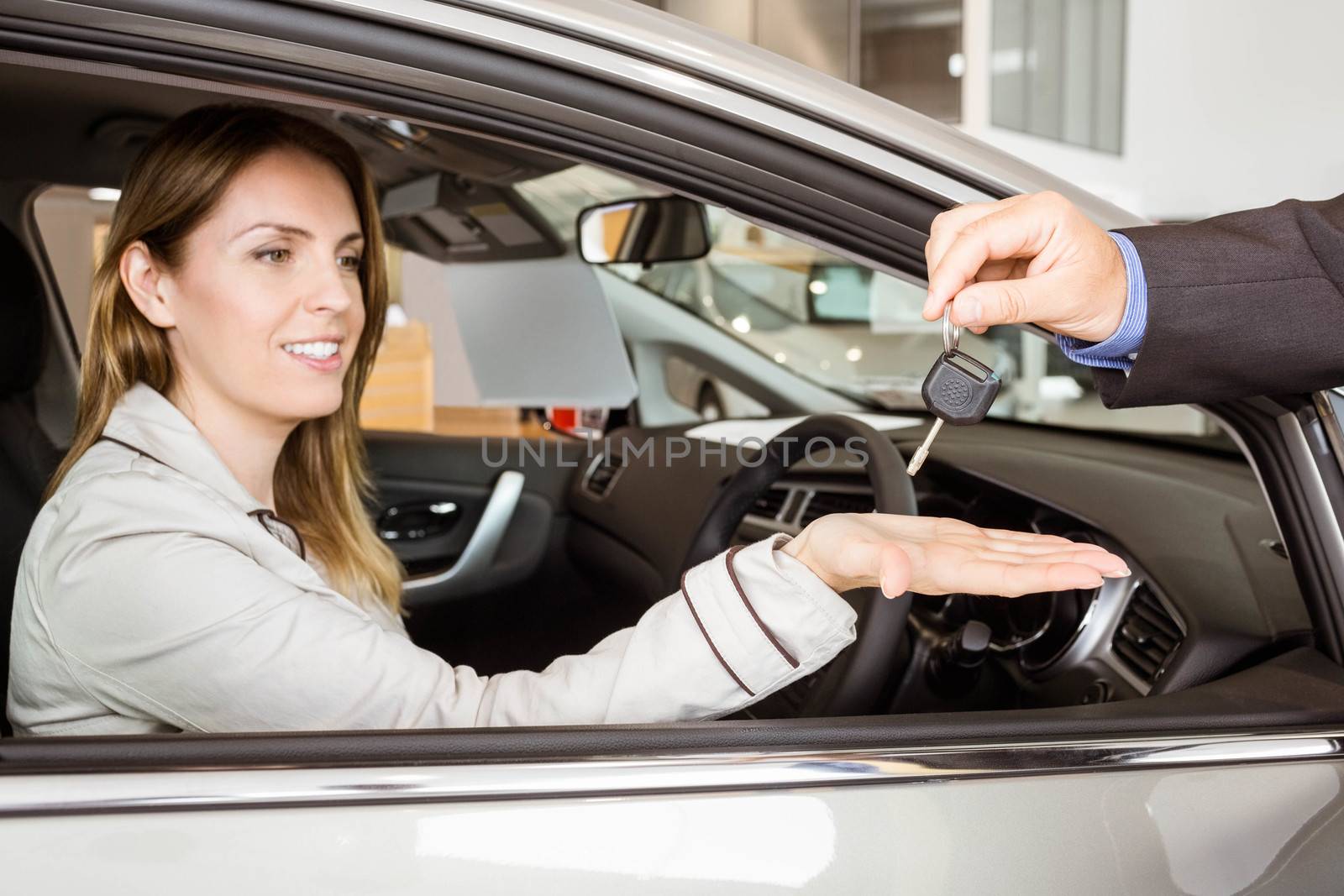 Salesman offering car key to a customers by Wavebreakmedia