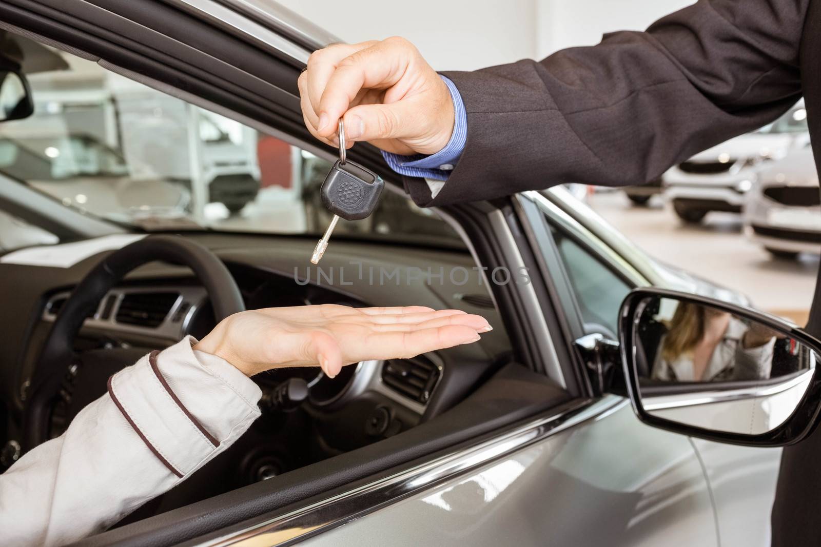Salesman offering car key to a customers by Wavebreakmedia
