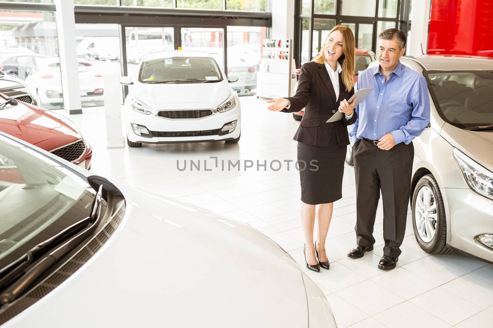 Smiling businesswoman showing car to customer by Wavebreakmedia