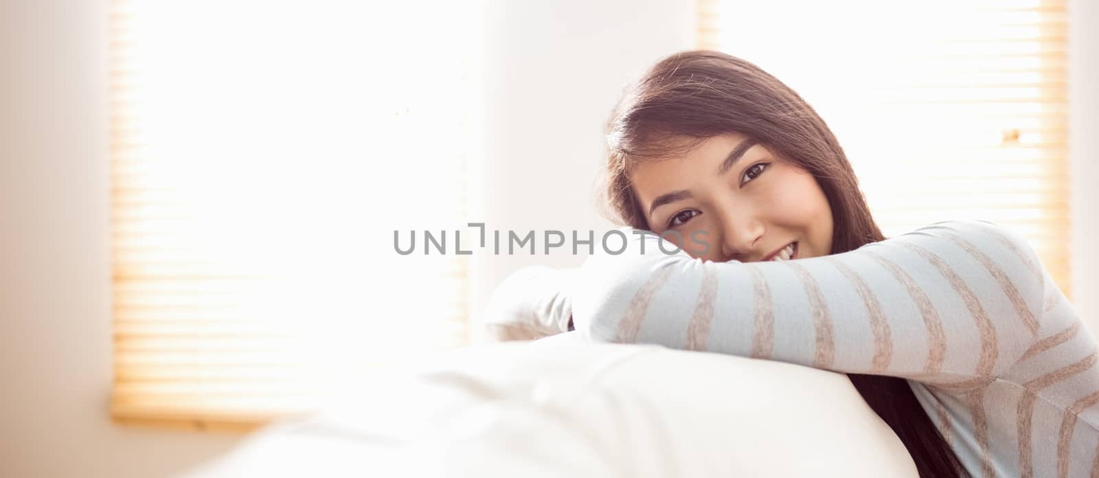 Asian woman relaxing on couch at home in the living room