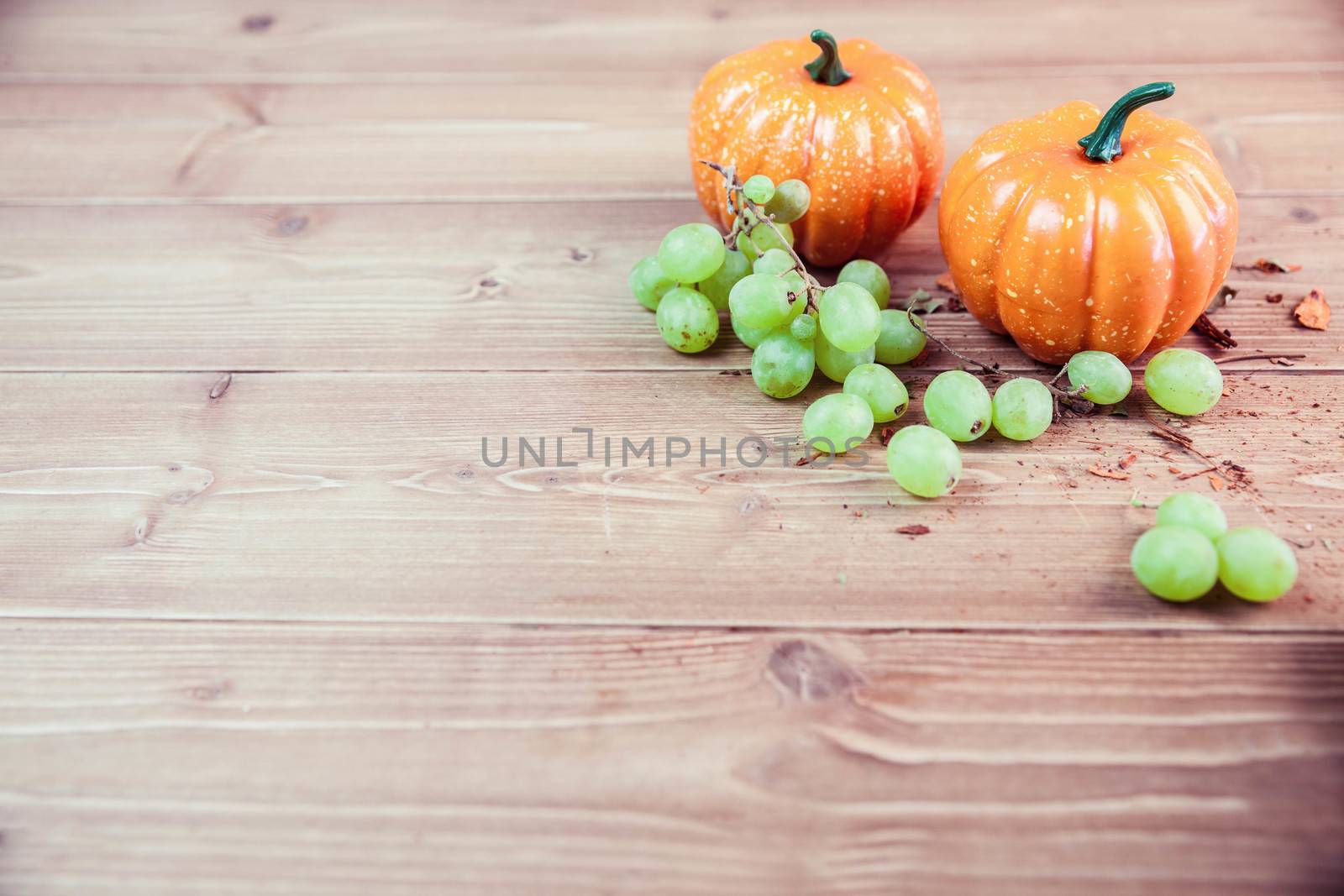 Pumpkin ornaments on desk with grapes