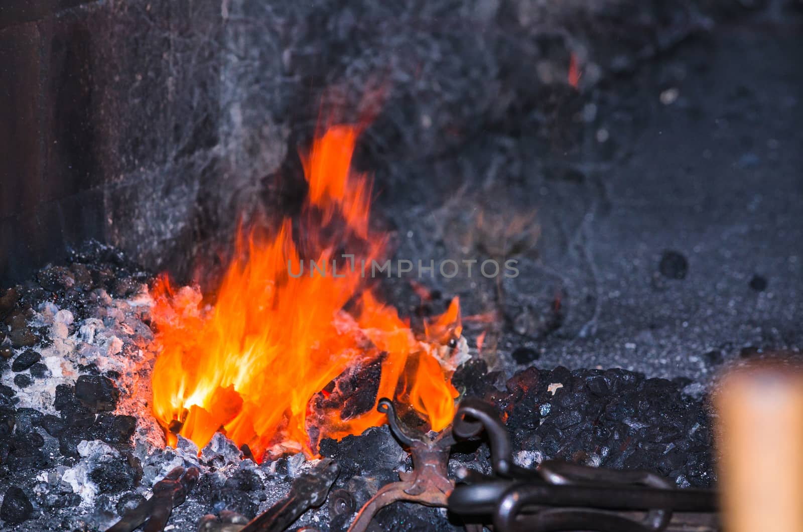 Embers and flame of a glowing red forge fire