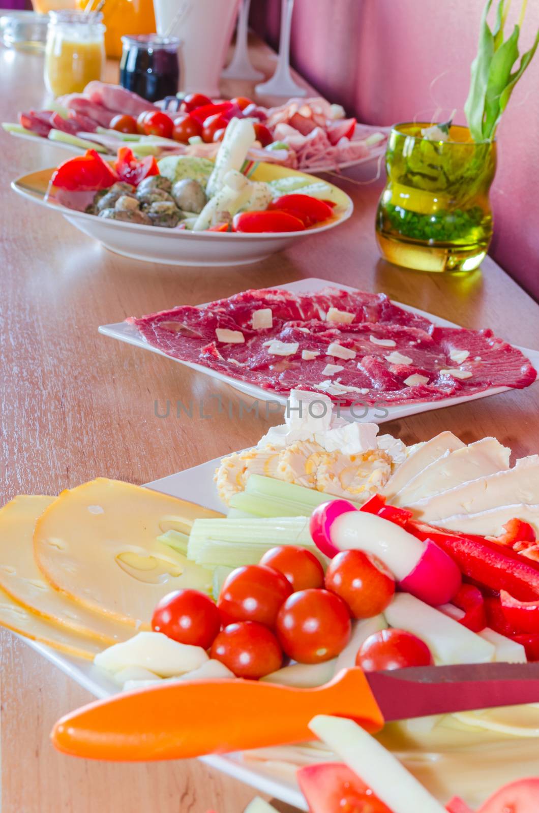 Buffet for a private party with salads and finger food on a cabinet.