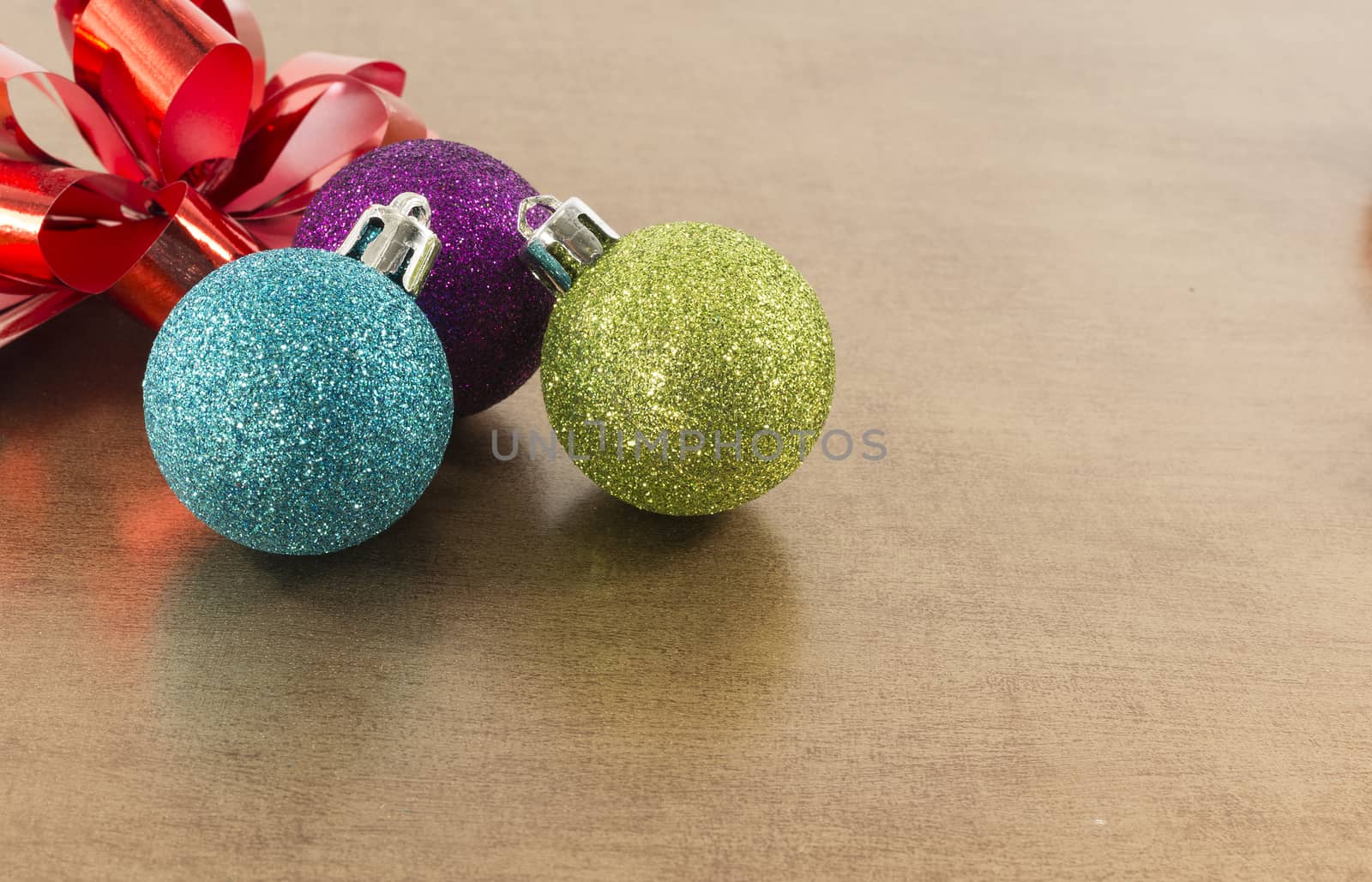 blue,pink and green christmas balls on brown gold background