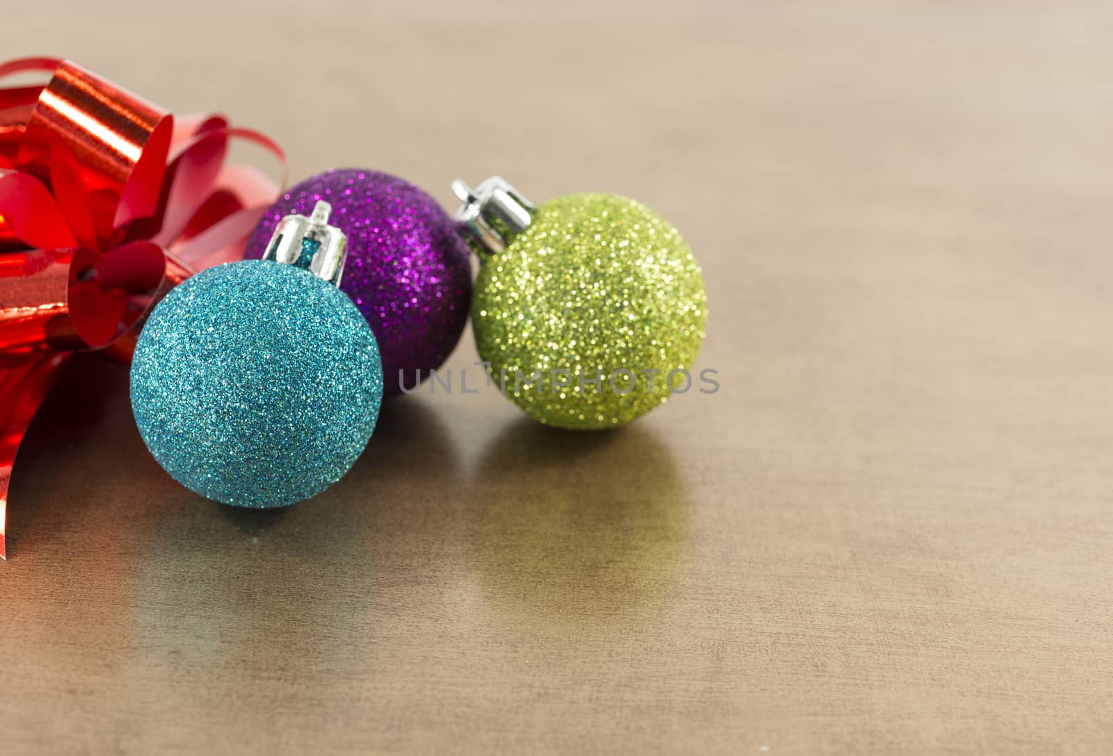 blue,pink and green christmas balls on brown gold background