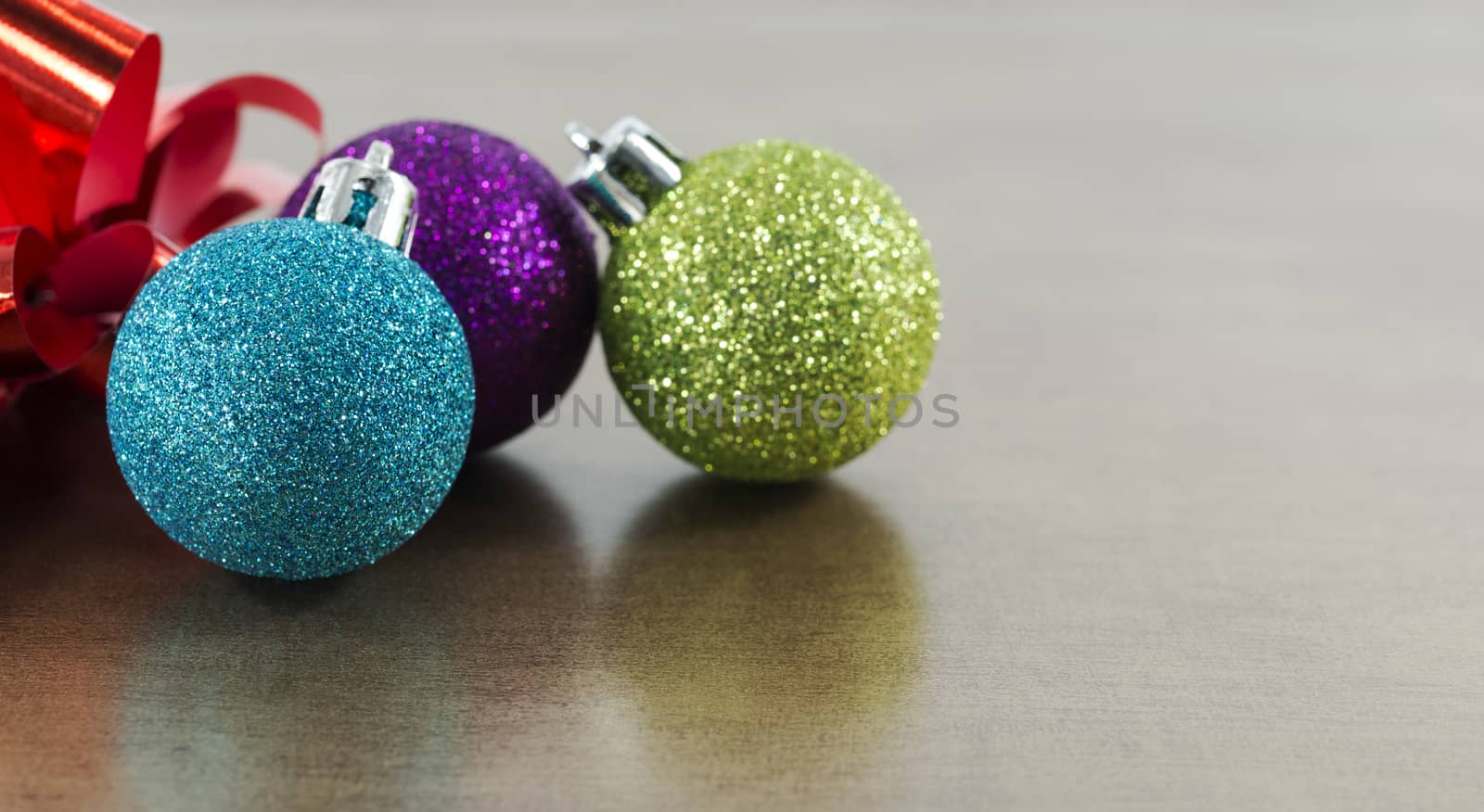 blue,pink and green christmas balls on brown gold background