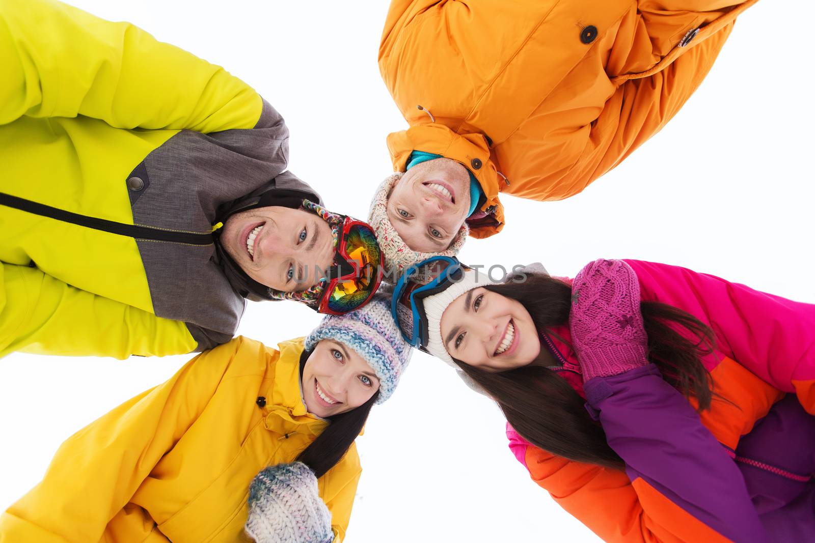 winter, leisure, friendship and people concept - happy friends standing in circle outdoors and looking down