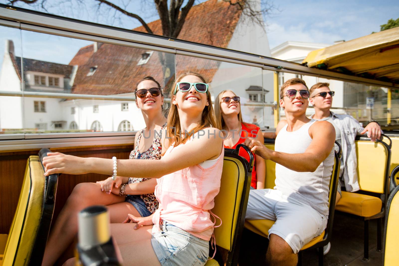 group of smiling friends traveling by tour bus by dolgachov