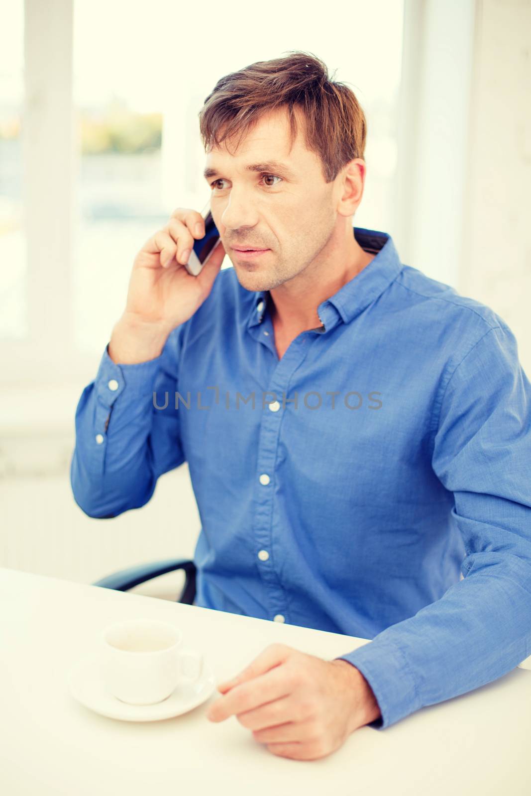 business, communication, modern technology concept - buisnessman with cell phone and cup of coffee