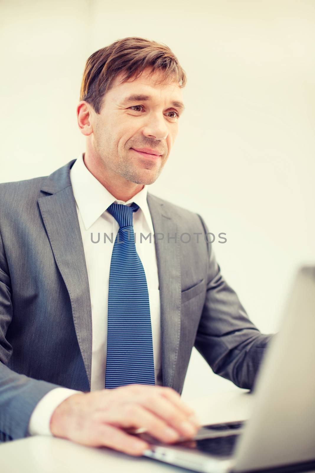 businessman with laptop in office by dolgachov