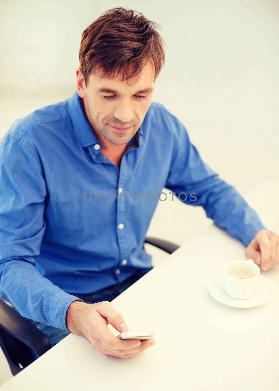 business, communication, modern technology concept - buisnessman with smartphone and cup of coffee