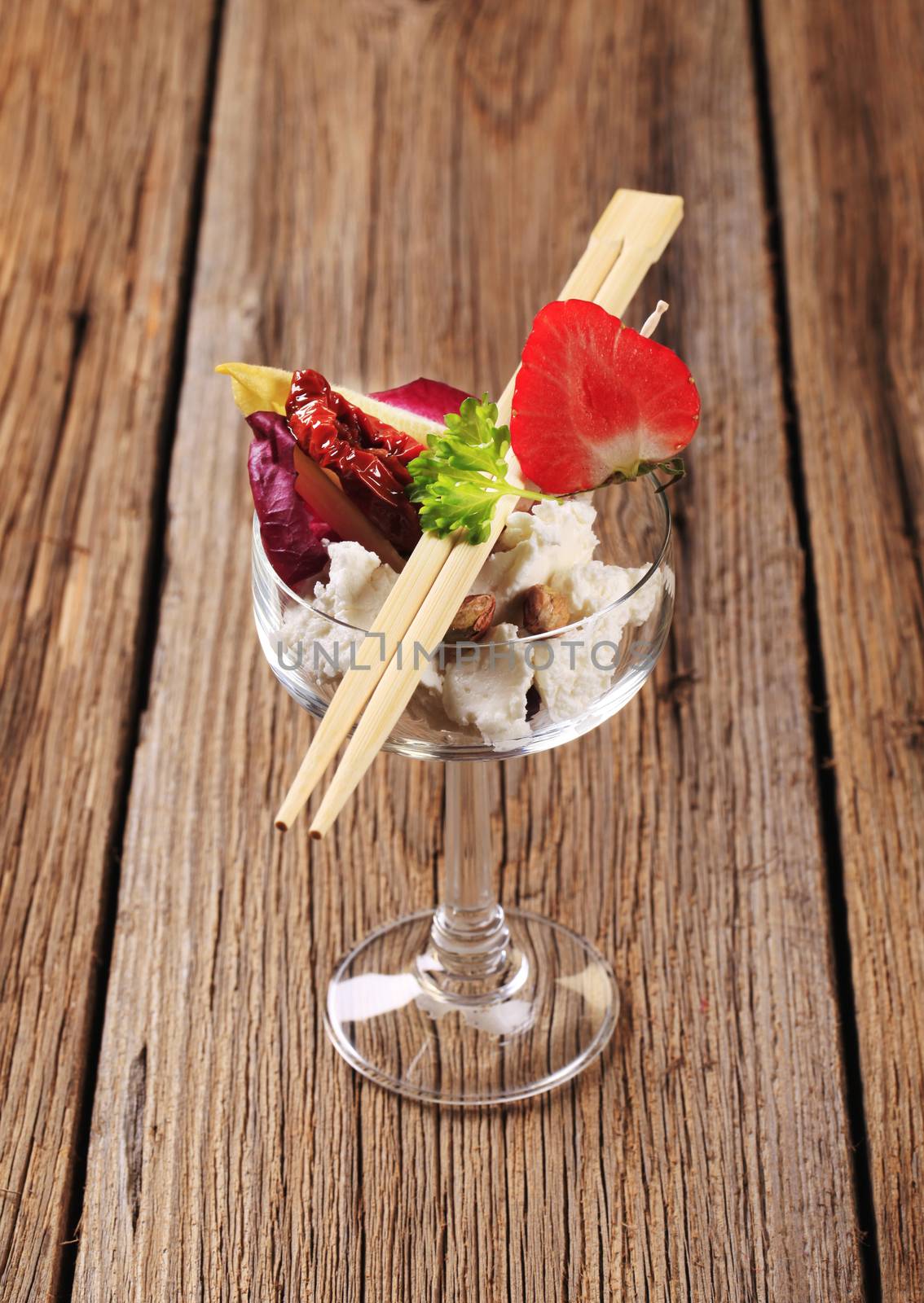 Cheese appetizer in a wine glass and chopsticks