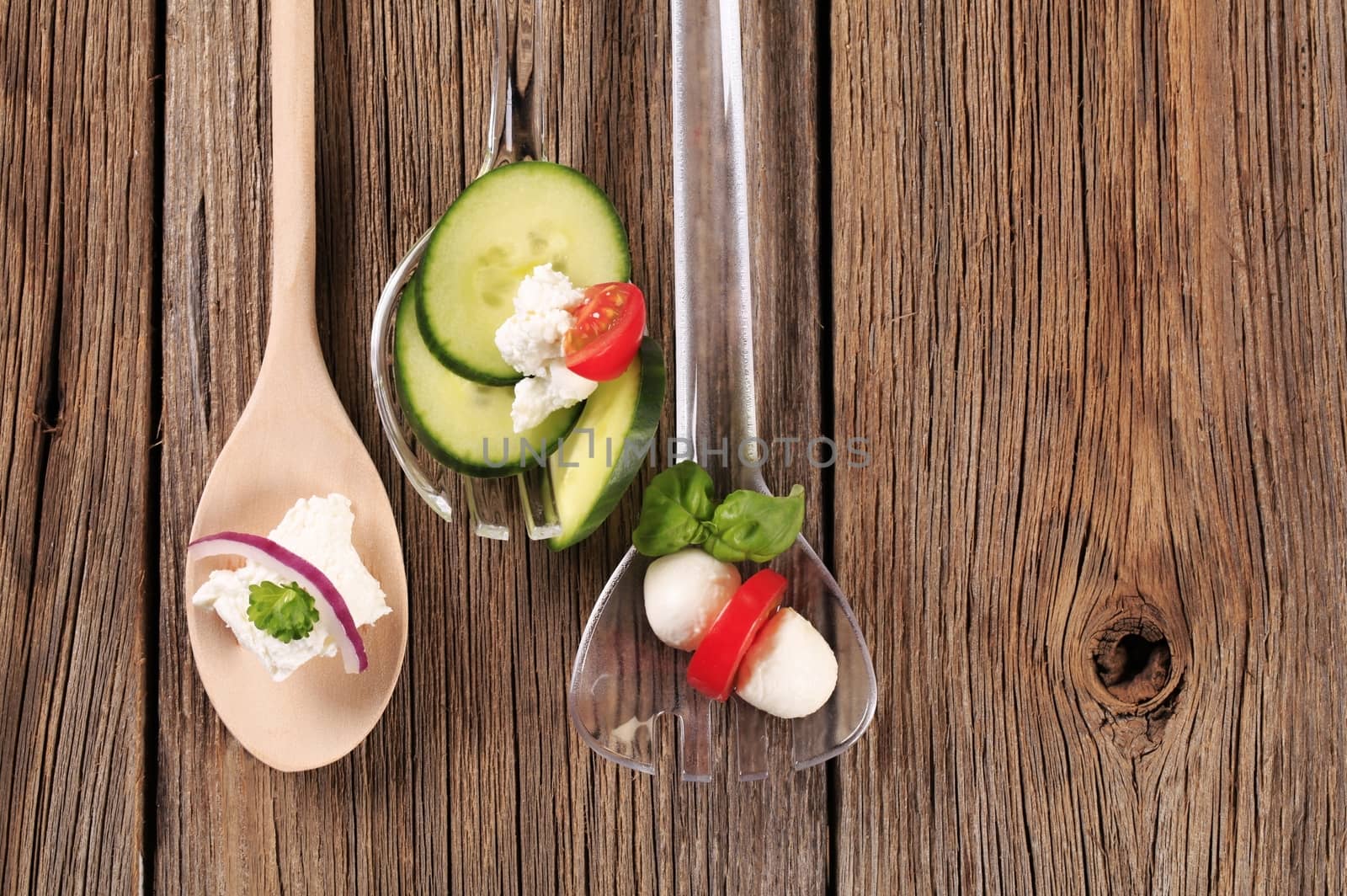 Fresh cheese and vegetables on salad spoons