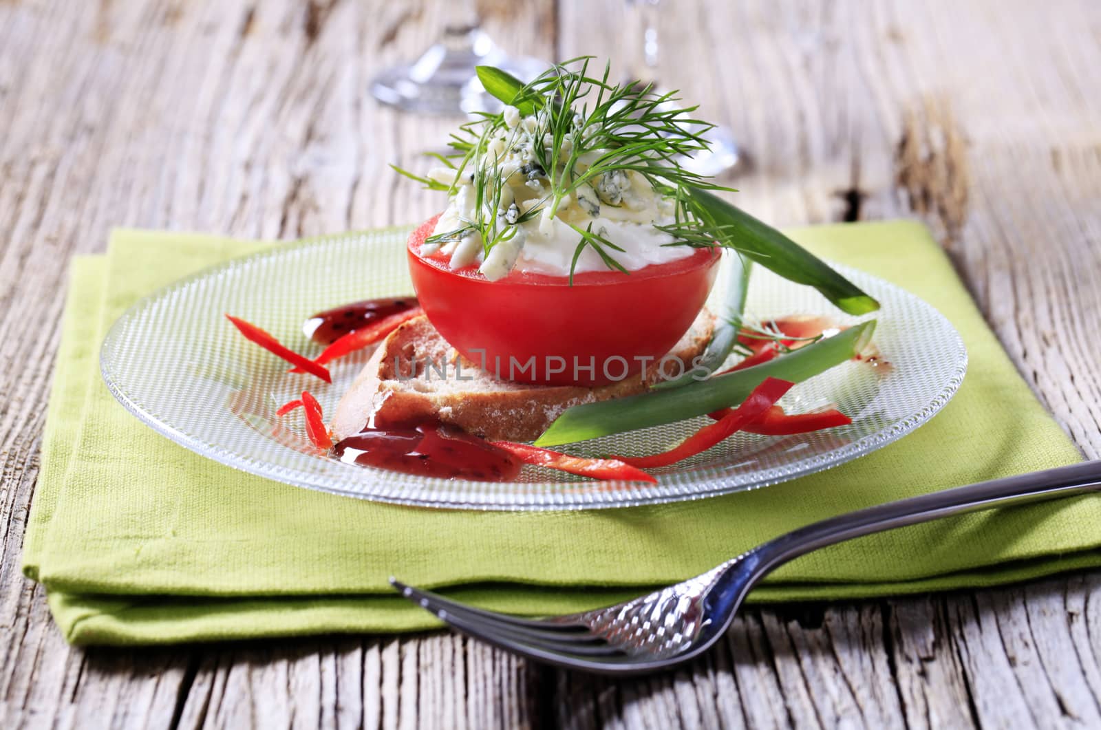 Cheese stuffed tomato on a slice of bread