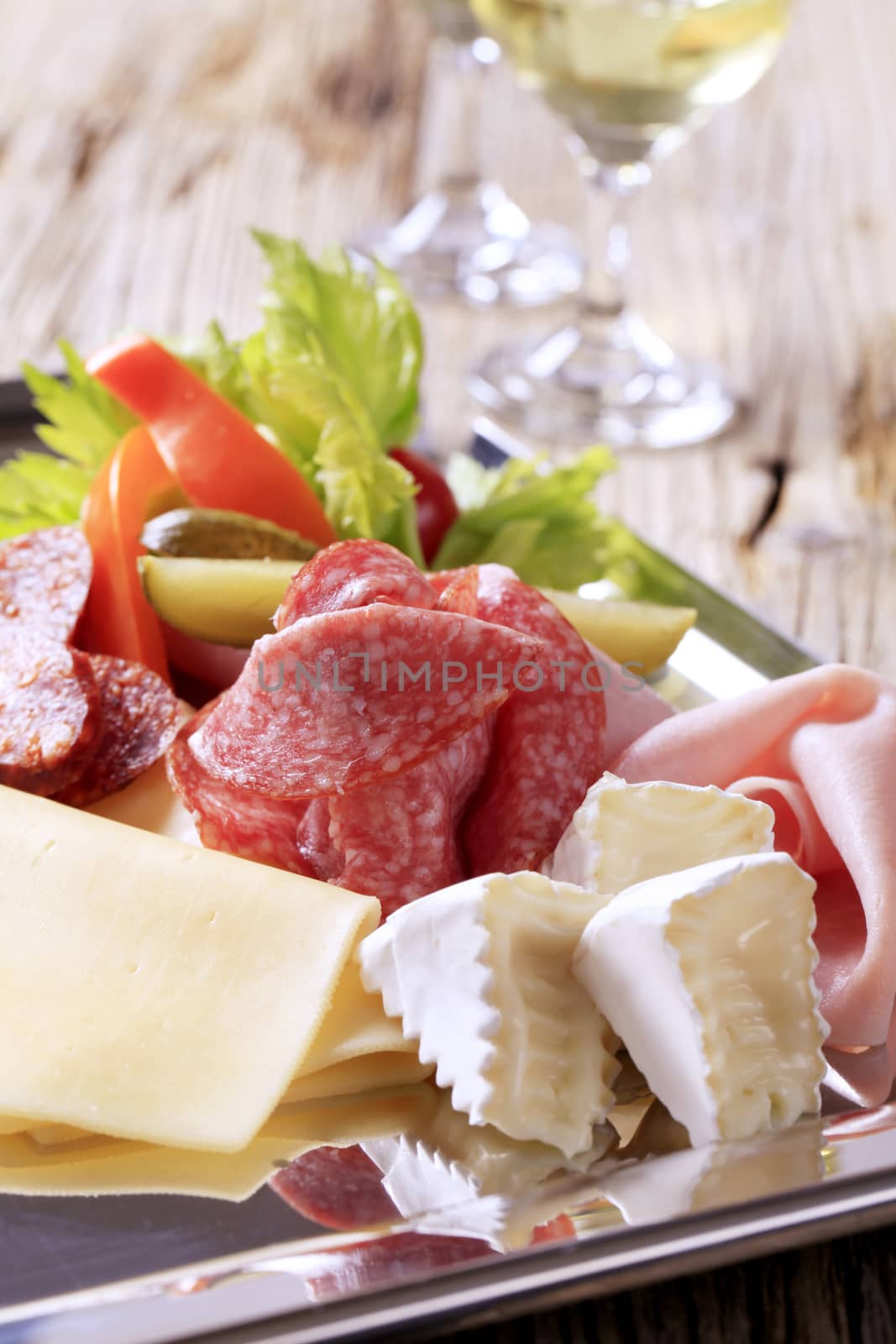 Slices of assorted cheeses, ham, and salami