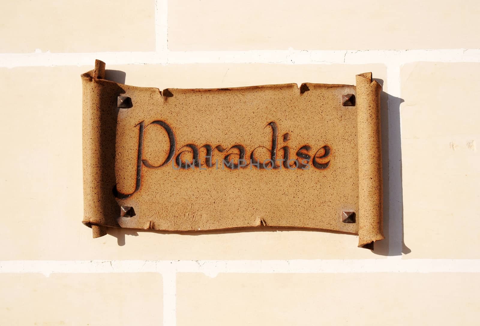 Ceramic sign reading Paradise on a wall