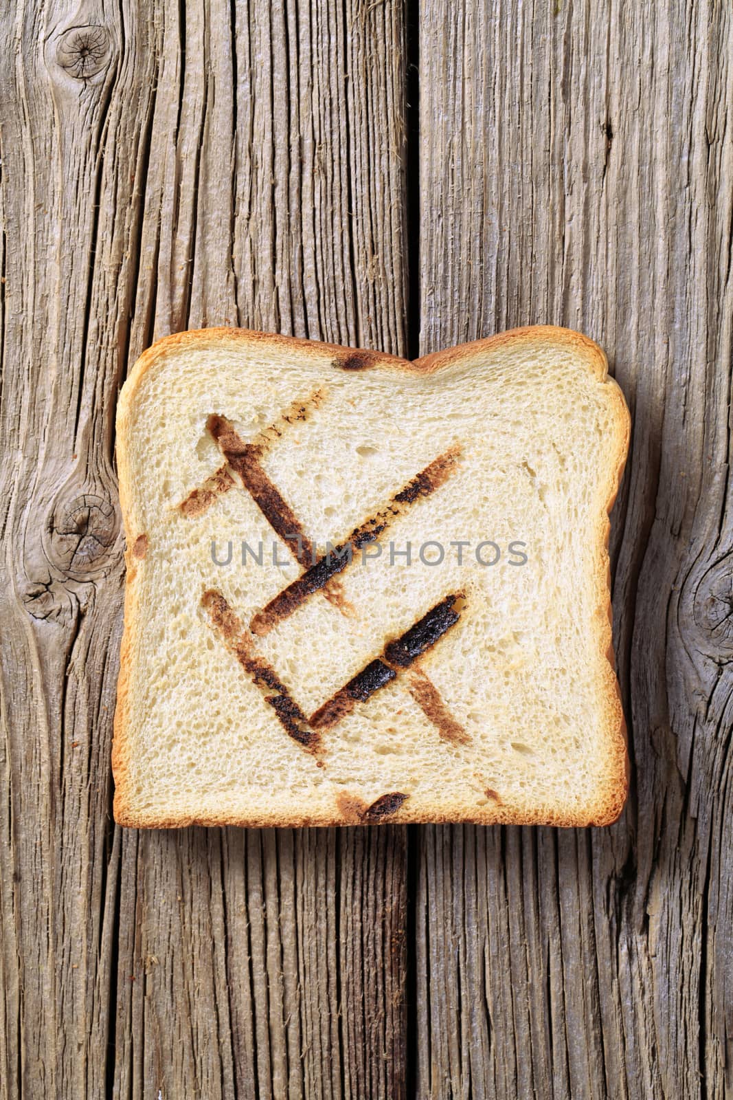 Slice of toasted bread on rough wood