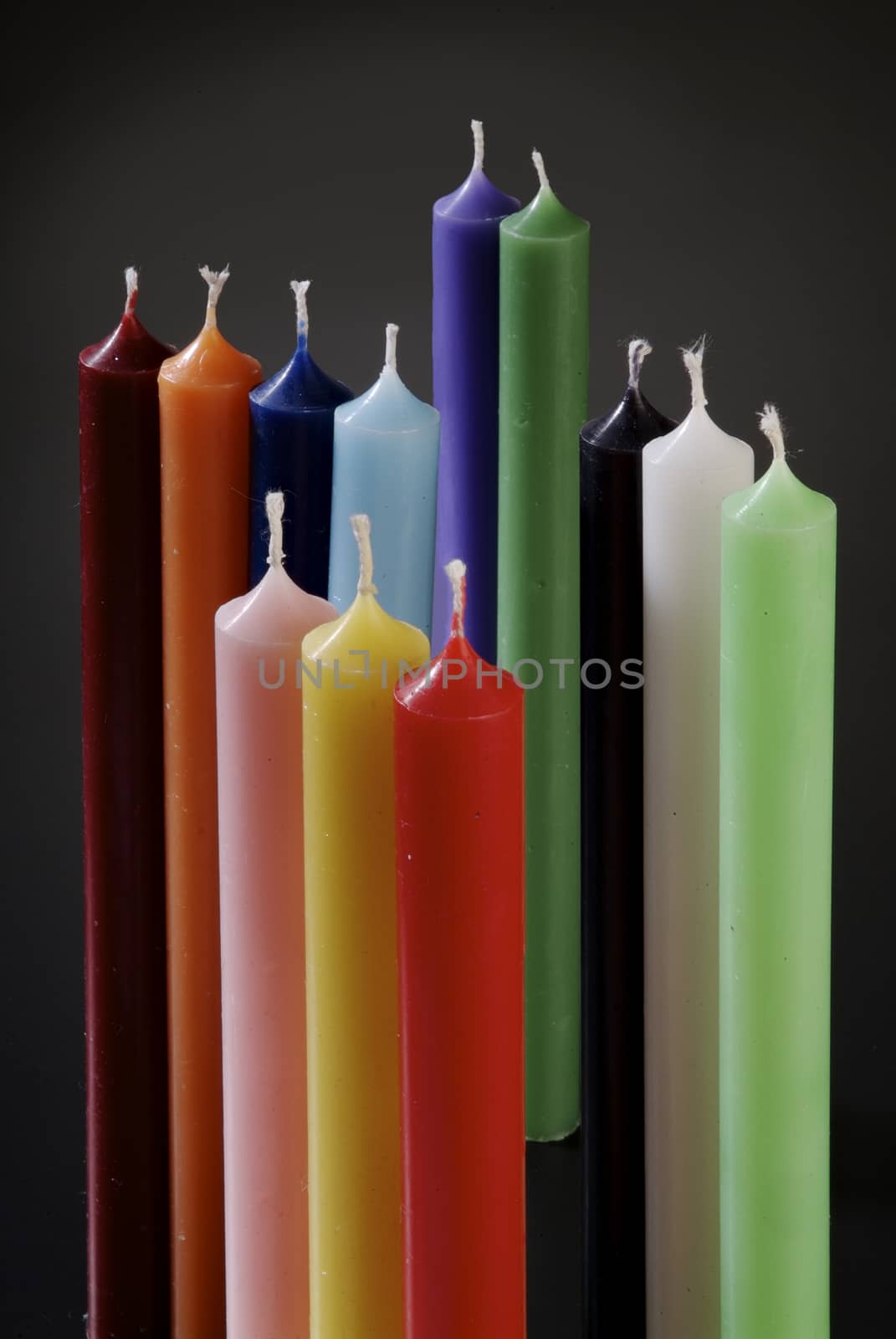 group of colorful cylindrical candles on a black background