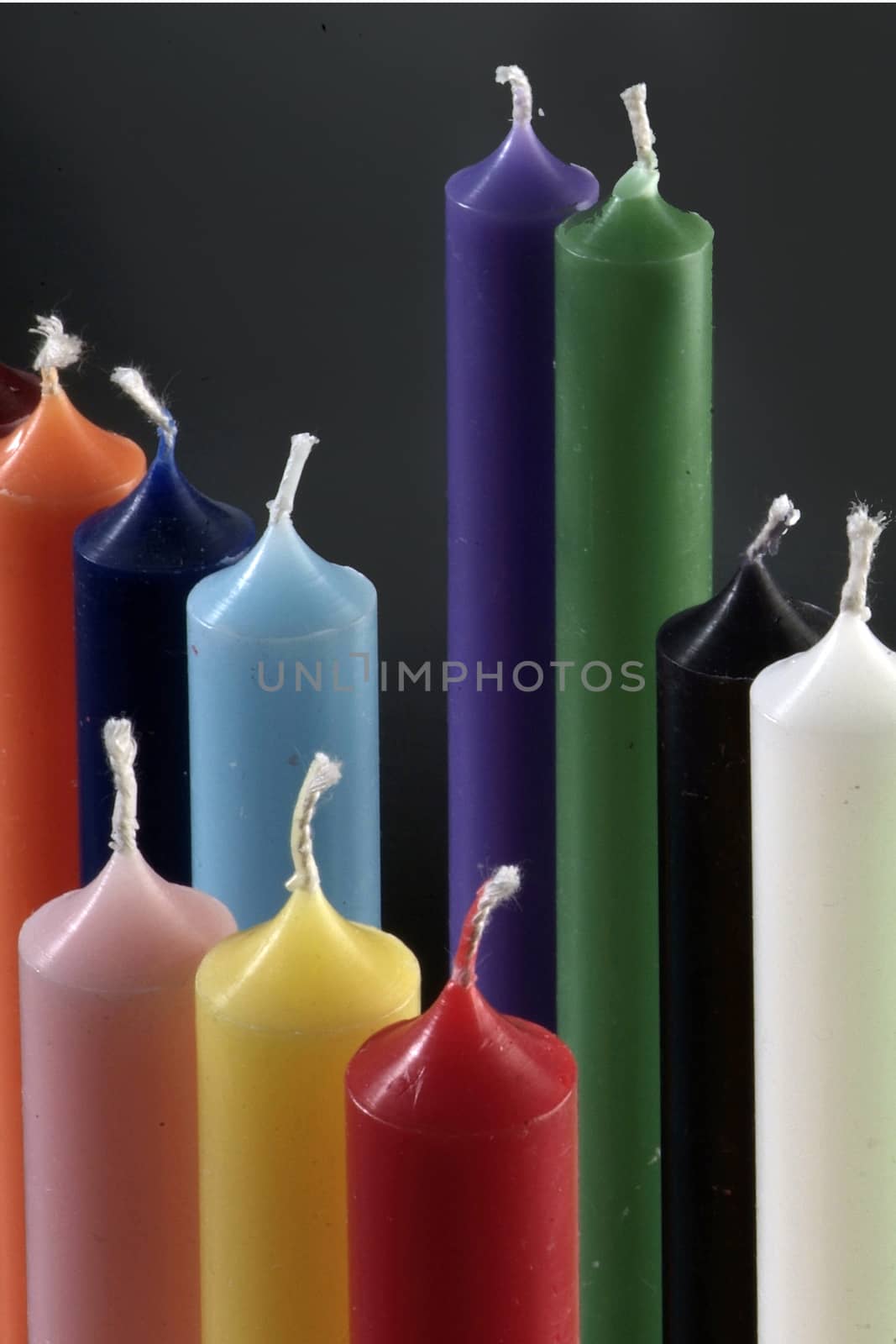 group of colorful cylindrical candles on a black background